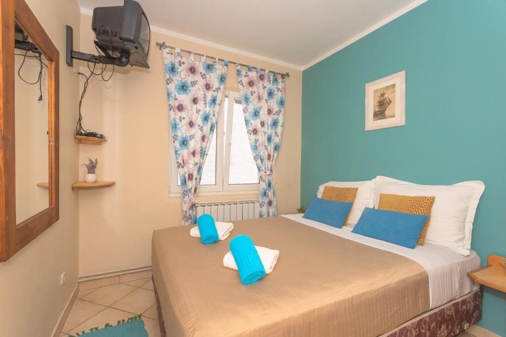 Room with two beds, blue cushions and air conditioning at Pansion Pirat