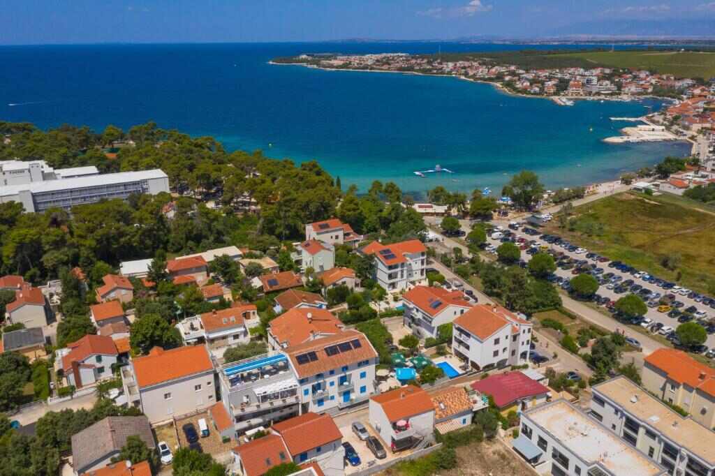Aerial view of Petrčane bay with turquoise sea and pine woods